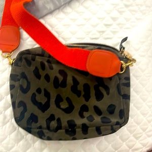 ClareV green leopard purse with orange strap. It is a light suede no holes.